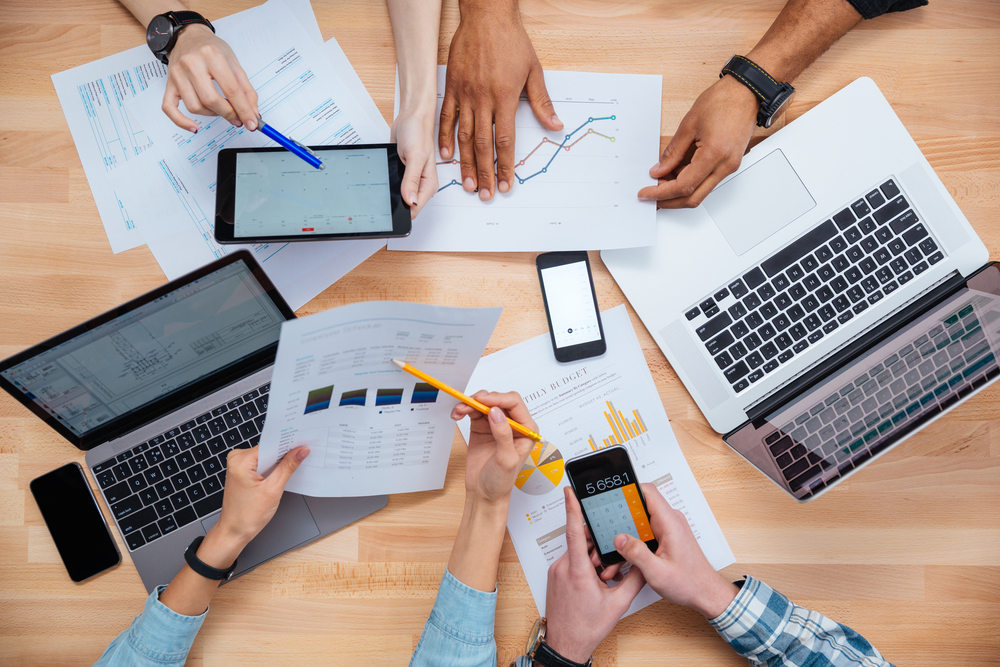 Business people using mobile phones and laptops, calculating and discussing charts and diagrams for financial reports